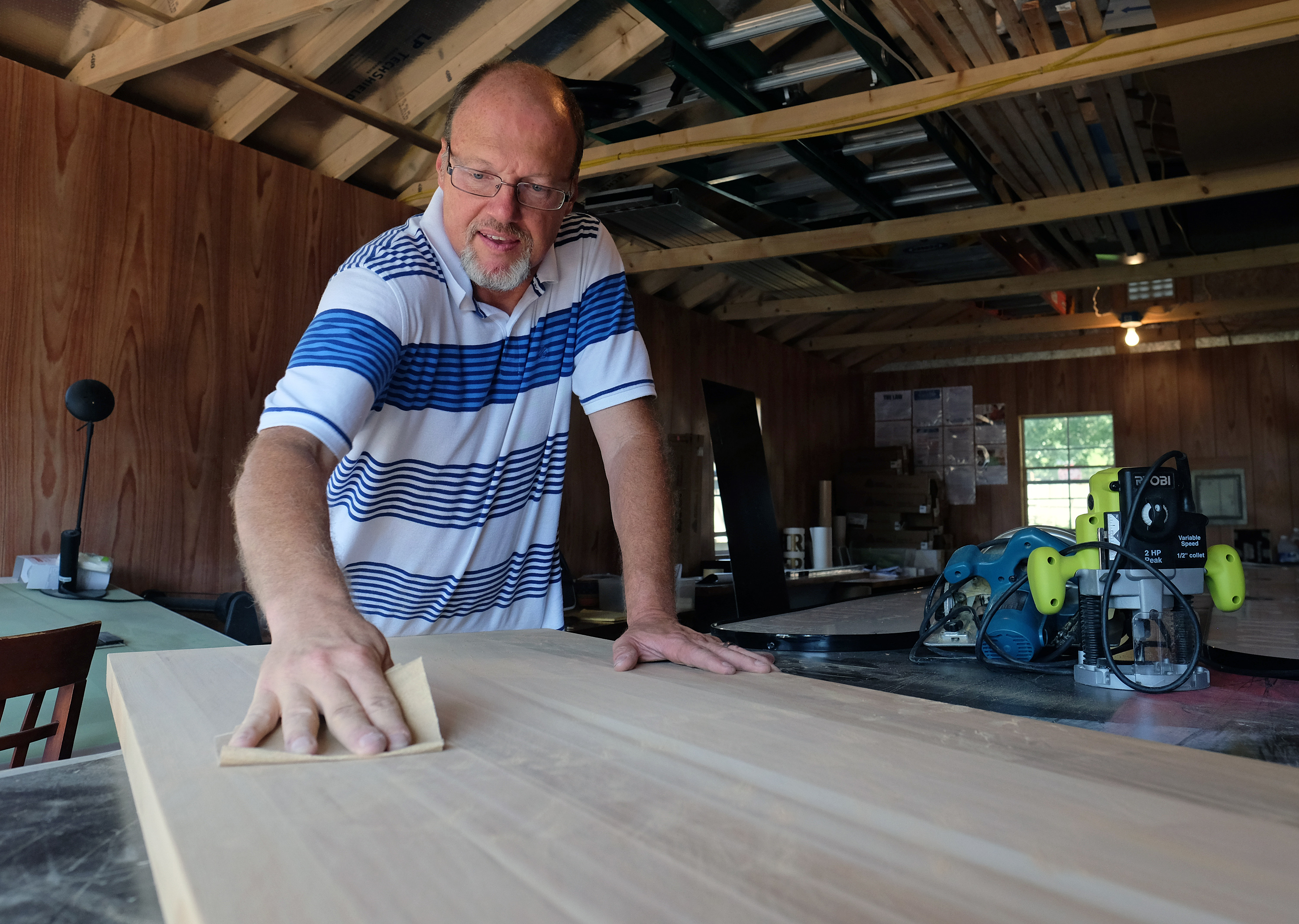 Mark Hackley, President Augusta Sign Company, sands a cedar board that was going to be the back ing of a metal sign, Friday, September 9, 2016. (Photo by Norm Shafer).