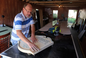 Mark Hackley, President Augusta Sign Company, sands an old sign he'd made in preparation for repainting it, Friday, September 9, 2016. (Photo by Norm Shafer).